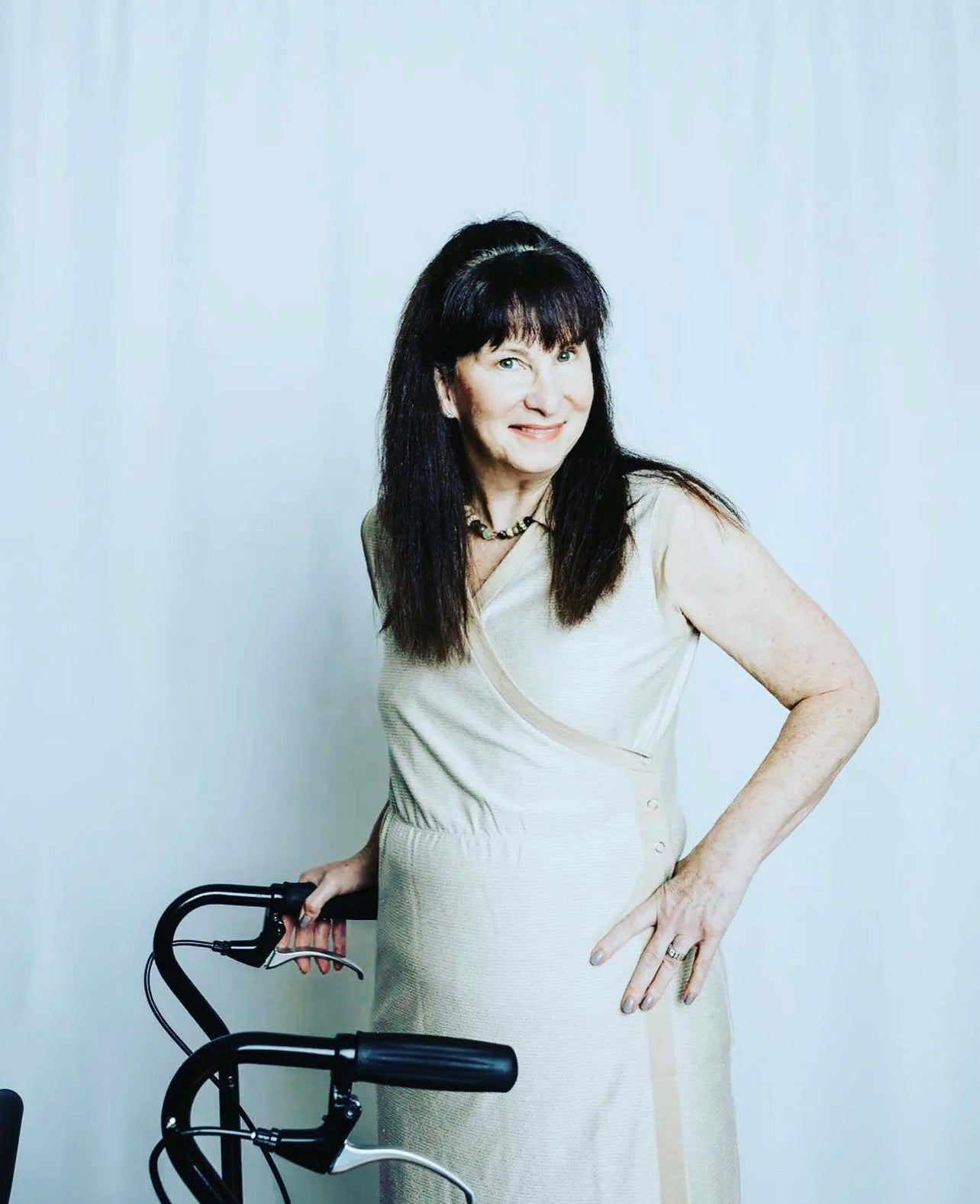 Elderly woman standing next to her mobility device while feeling comfortable in an adaptive dress