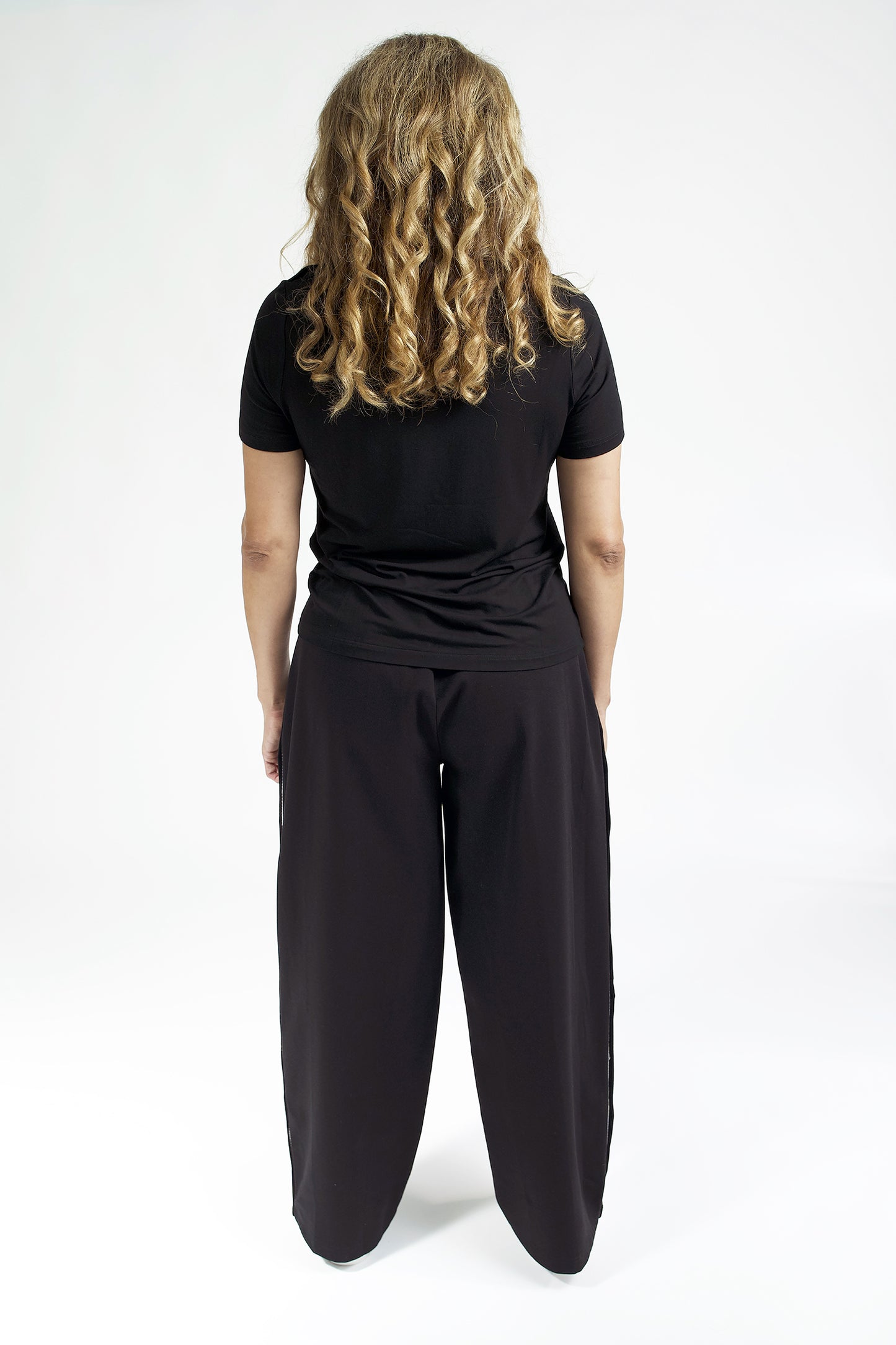 Image of women from the back wearing accessible clothing black pants and top